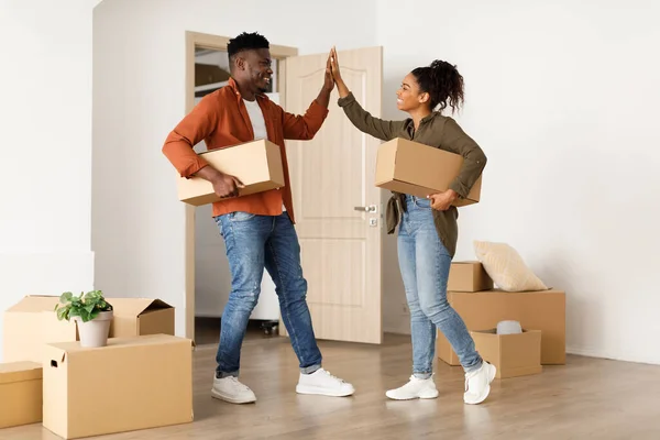 African Couple Moving New House Holding Boxes Memberikan High-Five Indoors — Stok Foto