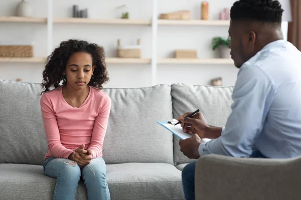 Verontrust Afrikaans Amerikaans meisje met gesprek met kind psycholoog — Stockfoto