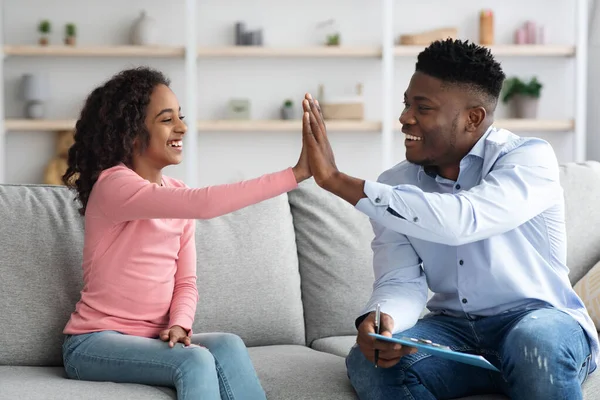 Glad afrikansk amerikansk flicka ger psykoterapeut high five — Stockfoto