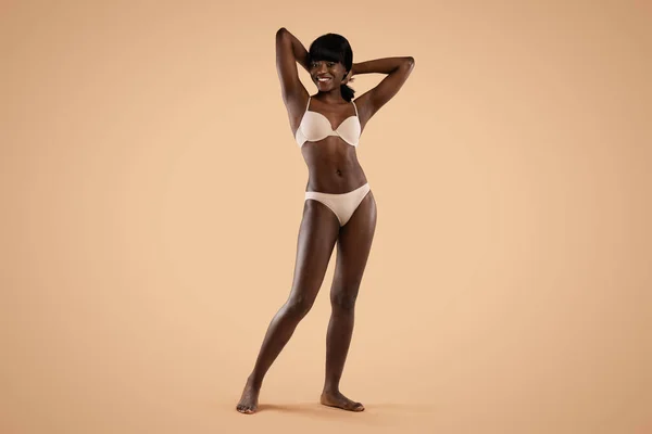 Schöne Afroamerikanerin in beiger Unterwäsche — Stockfoto