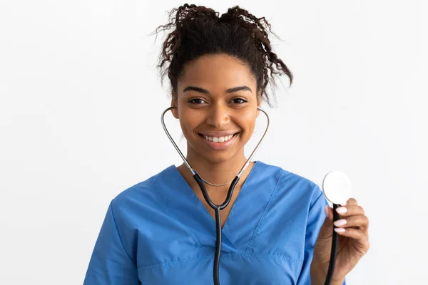 Retrato del médico negro sonriendo y mostrando estetoscopio —  Fotos de Stock