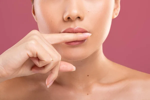 Unerkennbare Frau beißt sich in den Finger und zeigt schöne Lippen — Stockfoto