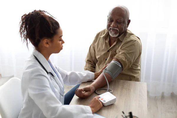 黑人女医生检查病人手上的测量压力 — 图库照片