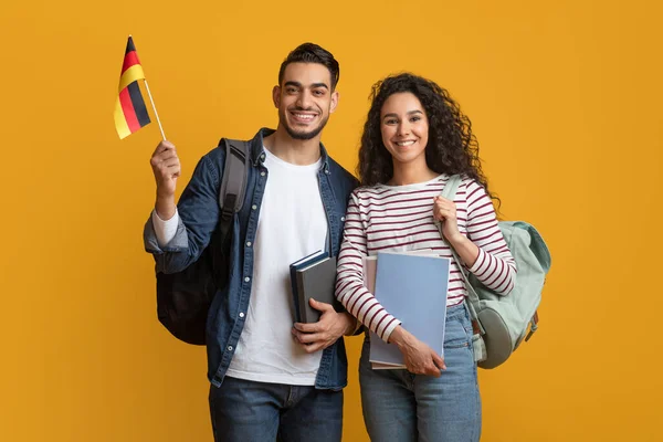 Educazione internazionale. Coppia di studenti del Medio Oriente con zaini con bandiera tedesca — Foto Stock