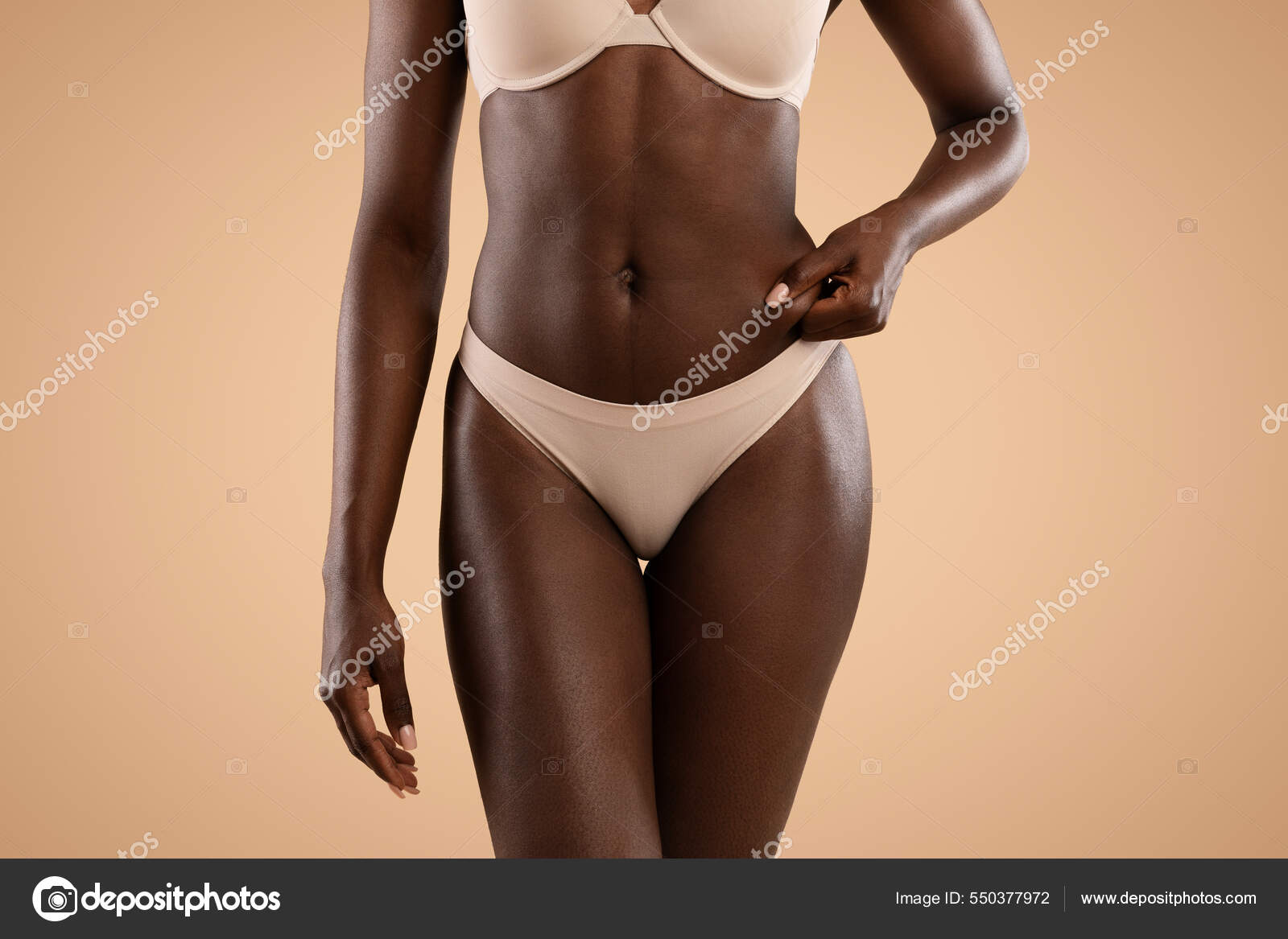 Unrecognizable black woman in underwear showing excessive fat on belly  Stock Photo by ©Milkos 550377972