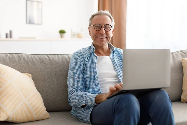 Confident smiling mature using laptop at home — Stock Photo, Image