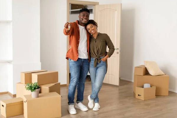 Glada afrikanska makar Visar Key Standing bland rörliga lådor inomhus — Stockfoto