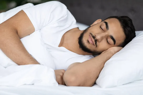 Портрет молодого красивого парня с Ближнего Востока, спящего в постели дома — стоковое фото