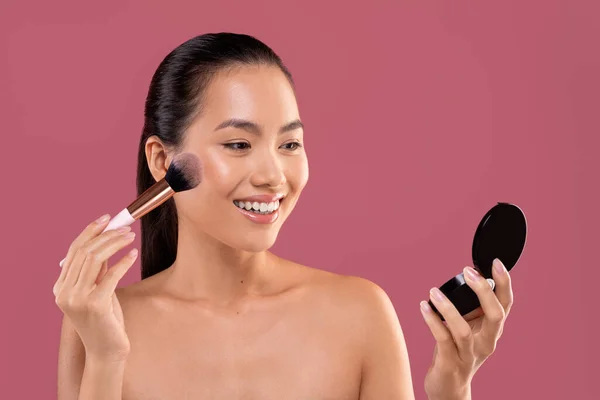 Hübsche Chinesin mit Make-up-Pinsel im Spiegel — Stockfoto