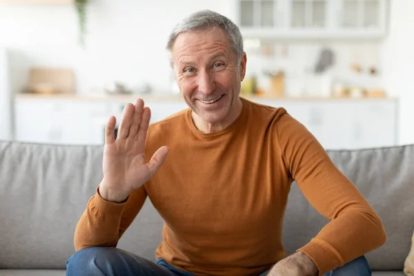 Greeting Concept. Mature man waving hand at camera — Stock Photo, Image