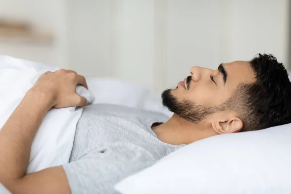 Hluboký spánek. Detailní záběr mladý Arab muž spí v posteli — Stock fotografie
