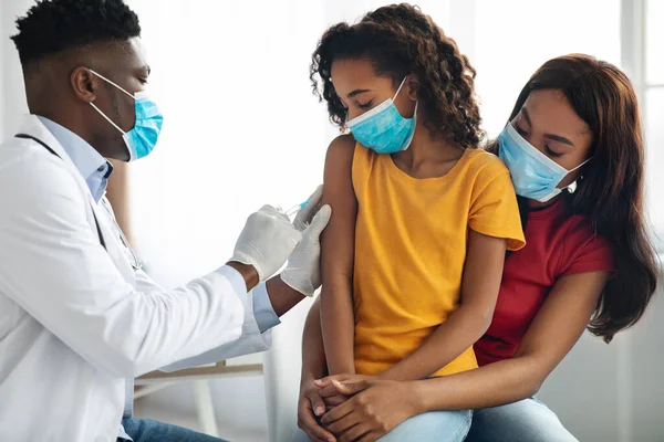 Afrikaanse Amerikaanse arts maakt vaccinatie in schouder voor kind — Stockfoto