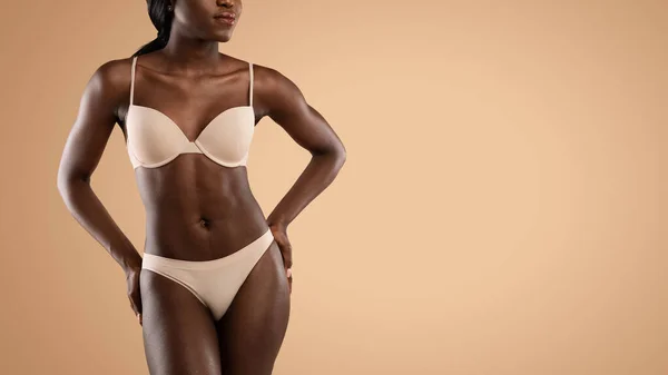 Cropped of black woman in underwear posing over beige — Stock Photo, Image