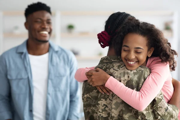 Feliz família negra cumprimentando mãe soldado de volta do exército — Fotografia de Stock