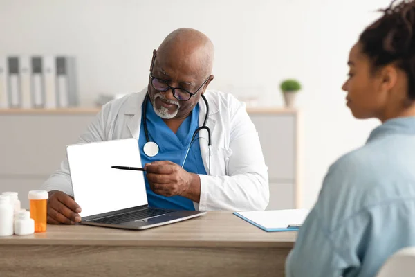 Опытный черный врач объясняет пациентке план лечения — стоковое фото