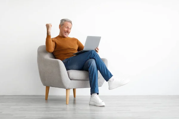 Felnőtt férfi használ laptop ünnepli siker remegő ököl — Stock Fotó