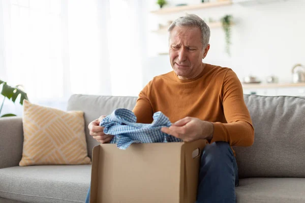 Droevige volwassen man uitpakken verkeerde pakket, levering fout — Stockfoto