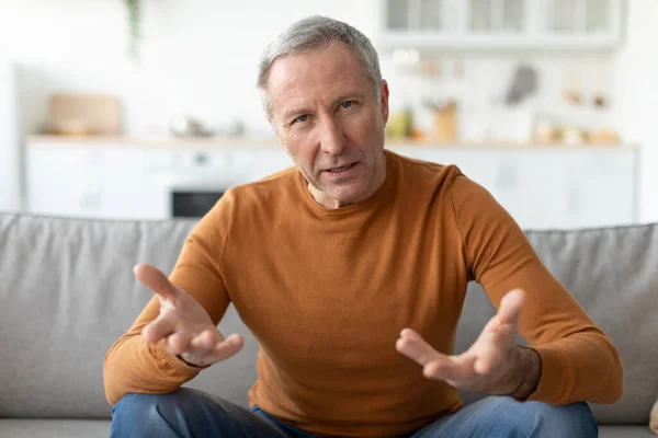 Mature man talking and gesturing to camera — Stock Photo, Image