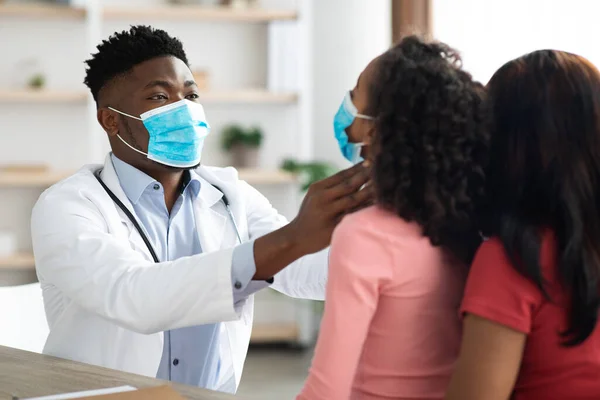 얼굴에 마스크를 쓴 흑인 의사 가작은 환자 편도선을 검사하는 모습 — 스톡 사진