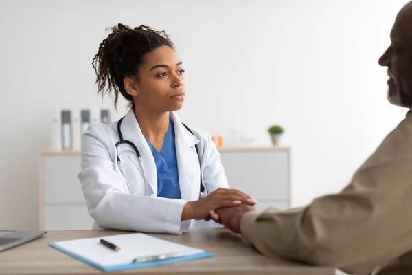 Gros plan du médecin noir femelle tenant les mains des patients masculins — Photo