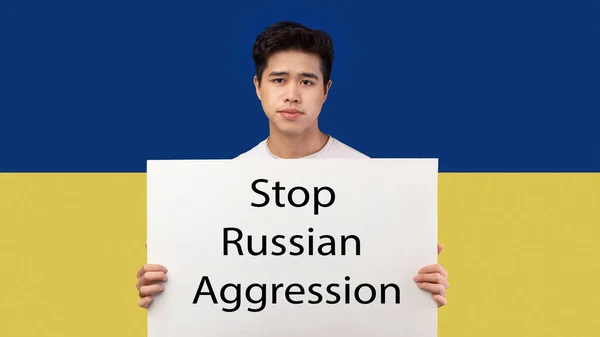 Asiático chico holding plancha pidiendo a parar rusa agresión —  Fotos de Stock