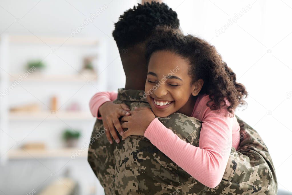 Portrait of happy african american teen girl hugging dad soldier