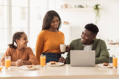 Neşeli Siyah Aile Laptop kullanıyor Mutfakta öğle yemeği yiyor