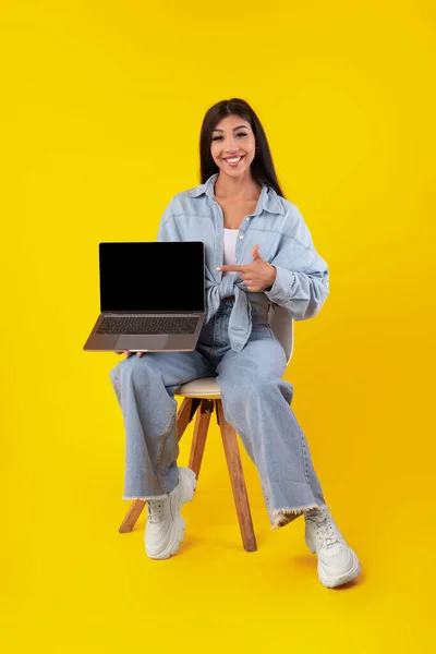 Mujer feliz apuntando a la pantalla del ordenador portátil vacío negro — Foto de Stock