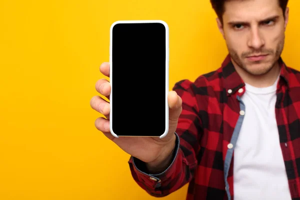 Сумний хлопець тримає порожній екран смартфона — стокове фото