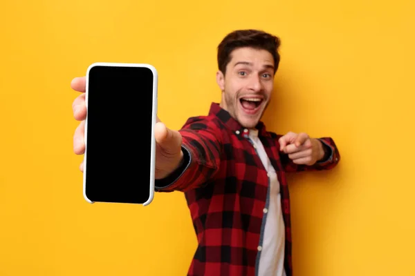 Шокований хлопець вказує на порожній екран смартфона — стокове фото
