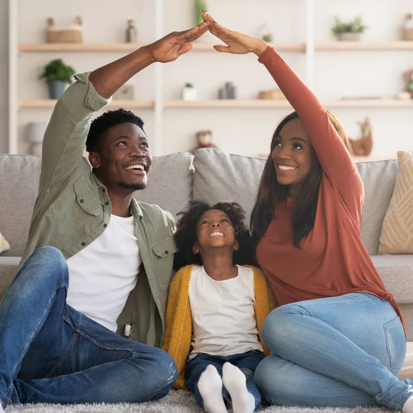 Familjevård. Svart mamma och pappa gör tak över händerna ovanför dottern — Stockfoto