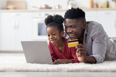 Neşeli Afro-Amerikan ailesi online alışveriş yapıyor.