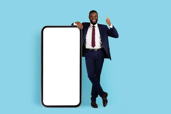 Business App. Χαρούμενος Αφροαμερικανός επιχειρηματίας στέκεται κοντά στο μεγάλο κενό Smartphone — Φωτογραφία Αρχείου