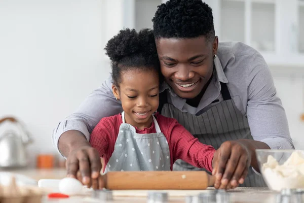 Czarny ojciec i córka toczenia ciasto ciasto i uśmiech — Zdjęcie stockowe