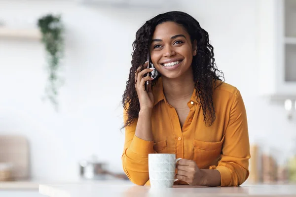 Ontspannen Afro-Amerikaanse dame die koffie drinkt, telefoneert — Stockfoto