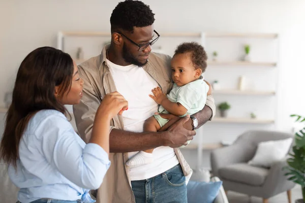 Pais negros felizes segurando bebê e brincando — Fotografia de Stock