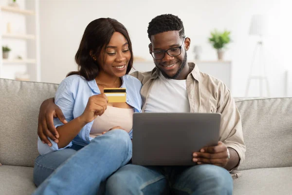 Černošky pár pomocí PC a debetní kreditní karty doma — Stock fotografie