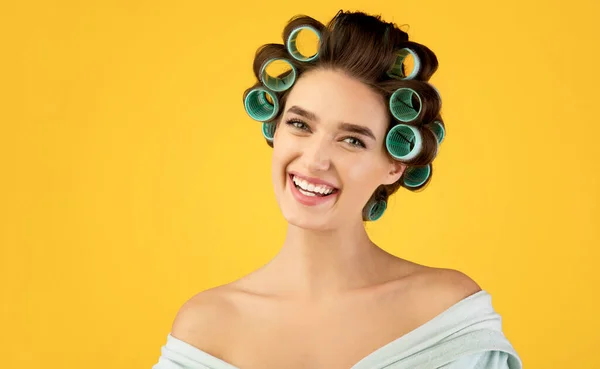 Retrato de mulher alegre com encrespadores de cabelo posando, fundo amarelo — Fotografia de Stock