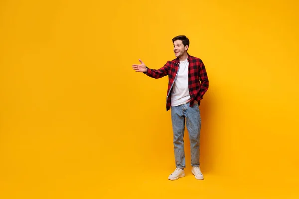 Portrait de jeune homme heureux posant au studio jaune — Photo