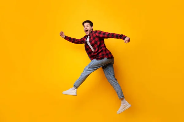 Joven excitado saltando en el estudio naranja — Foto de Stock