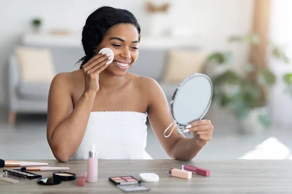 Wanita hitam muda yang bahagia menerapkan make up dan tersenyum — Stok Foto