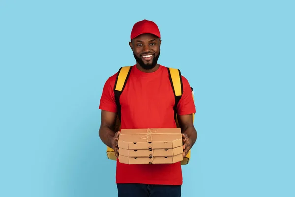 Retrato del repartidor negro en uniforme que sostiene la pila de cajas de pizza — Foto de Stock