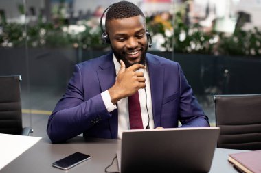 Yakışıklı siyah yönetici çalışanla video görüşmesi yapıyor.
