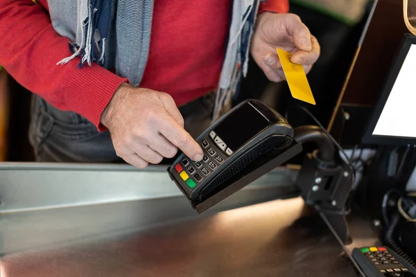 Cliente masculino irreconhecível pagando com cartão de crédito — Fotografia de Stock