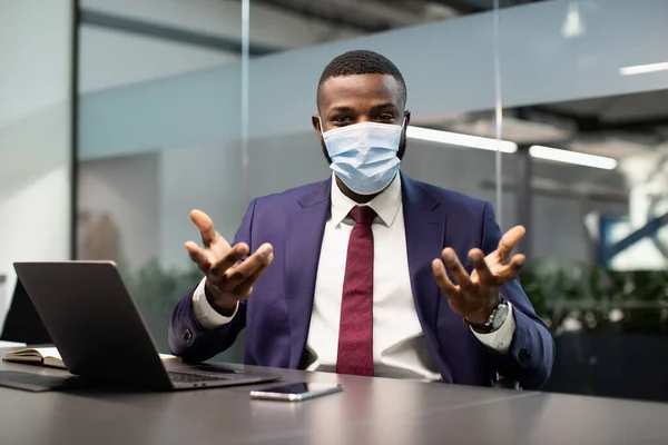 Gerente preto na máscara facial trabalhando no escritório, tendo conferência — Fotografia de Stock