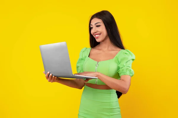 Veselá mladá žena pomocí notebooku ve studiu — Stock fotografie
