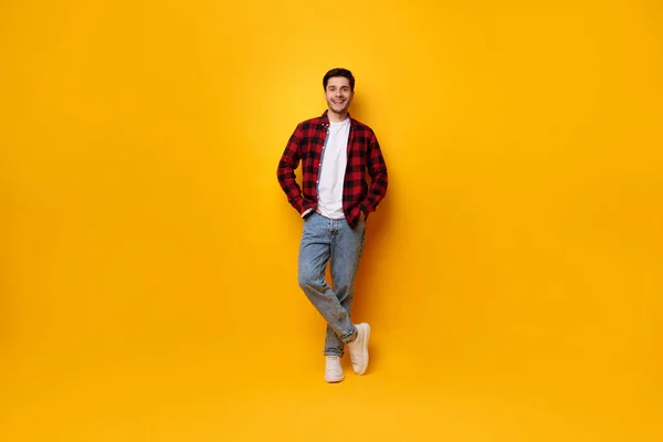 Retrato de un joven feliz posando en un estudio amarillo — Foto de Stock