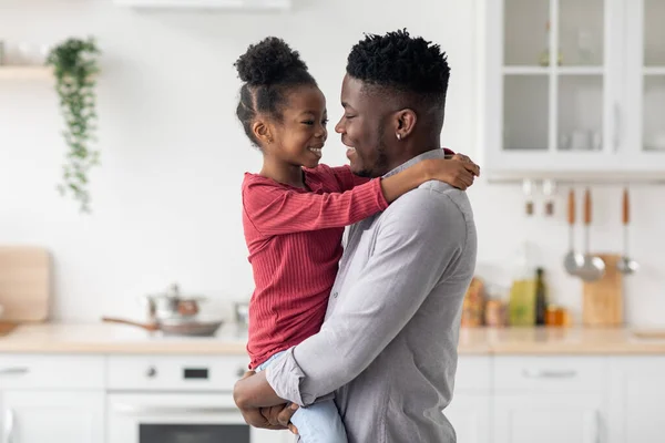 Kochający czarny ojciec trzymający swoją córeczkę za ręce — Zdjęcie stockowe