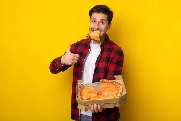 Funny Guy Holding Box comiendo pizza mostrando el pulgar hacia arriba — Foto de Stock