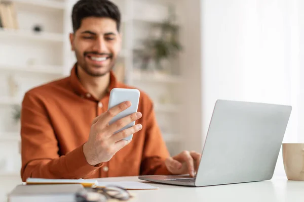 Retrato del hombre sonriente usando smartphone y PC en casa — Foto de Stock